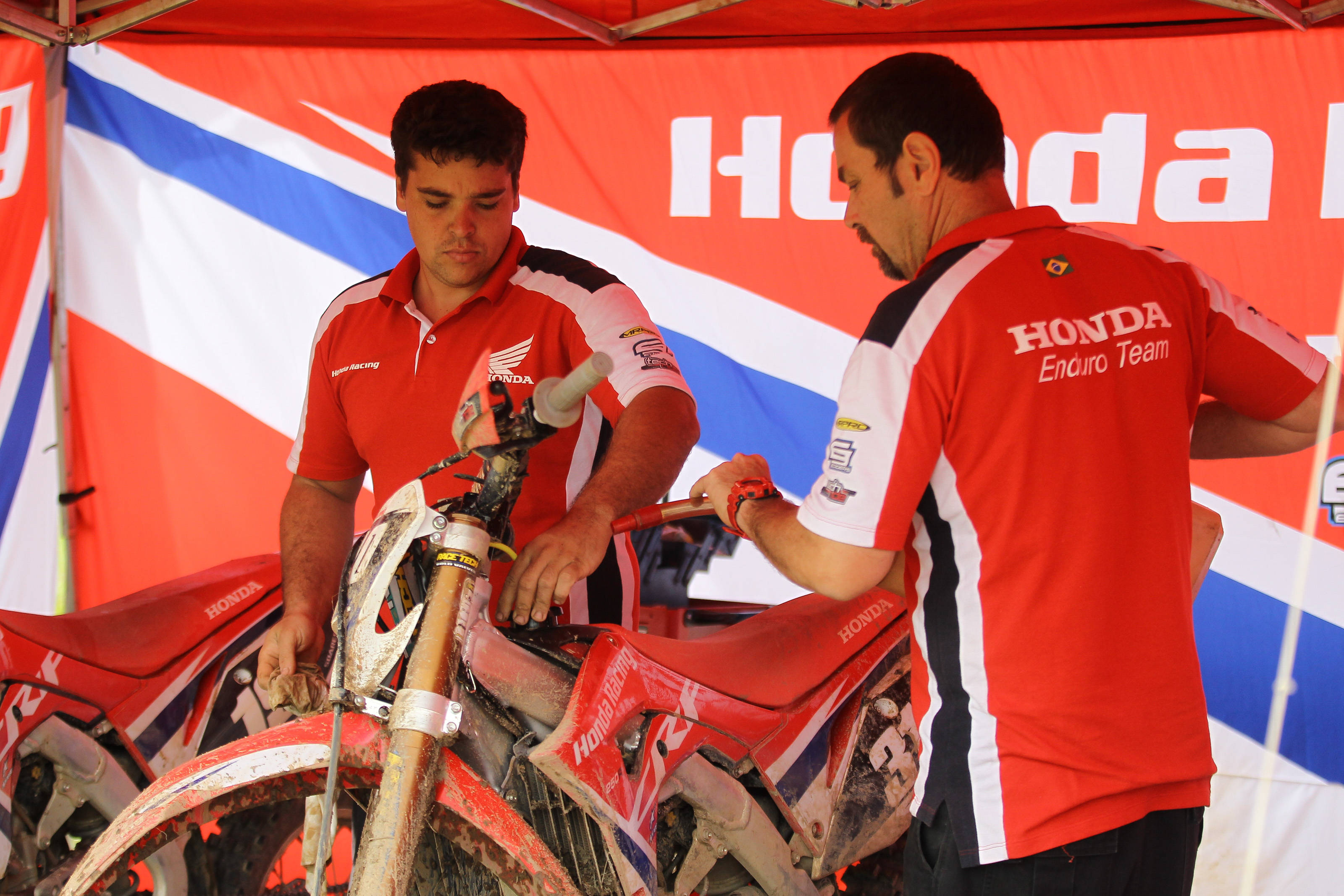 Time de Enduro fazendo manutenção de Moto Honda Off Road