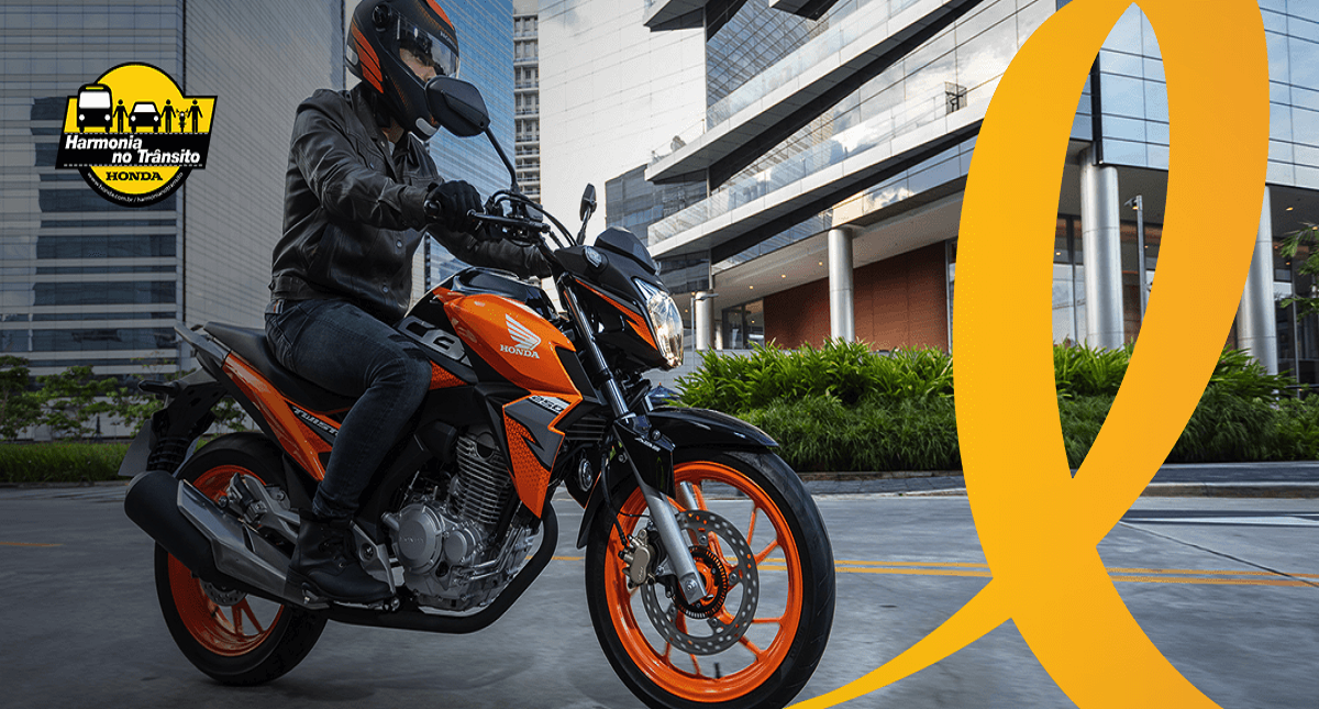 Piloto e sua moto Honda com aplicação do logo harmonia no trânsito e maio amarelo