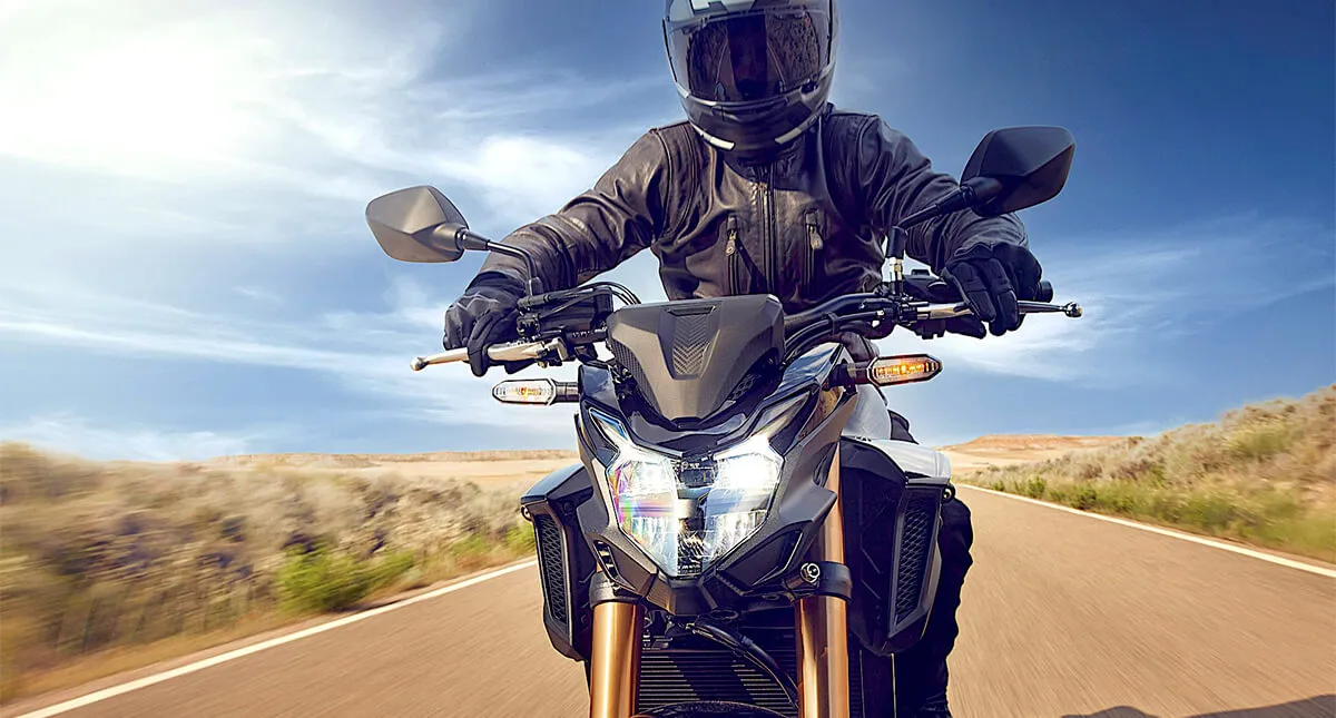 Imagem frontal de um piloto com sua motocicleta Honda CB 500F 2024 na estrada