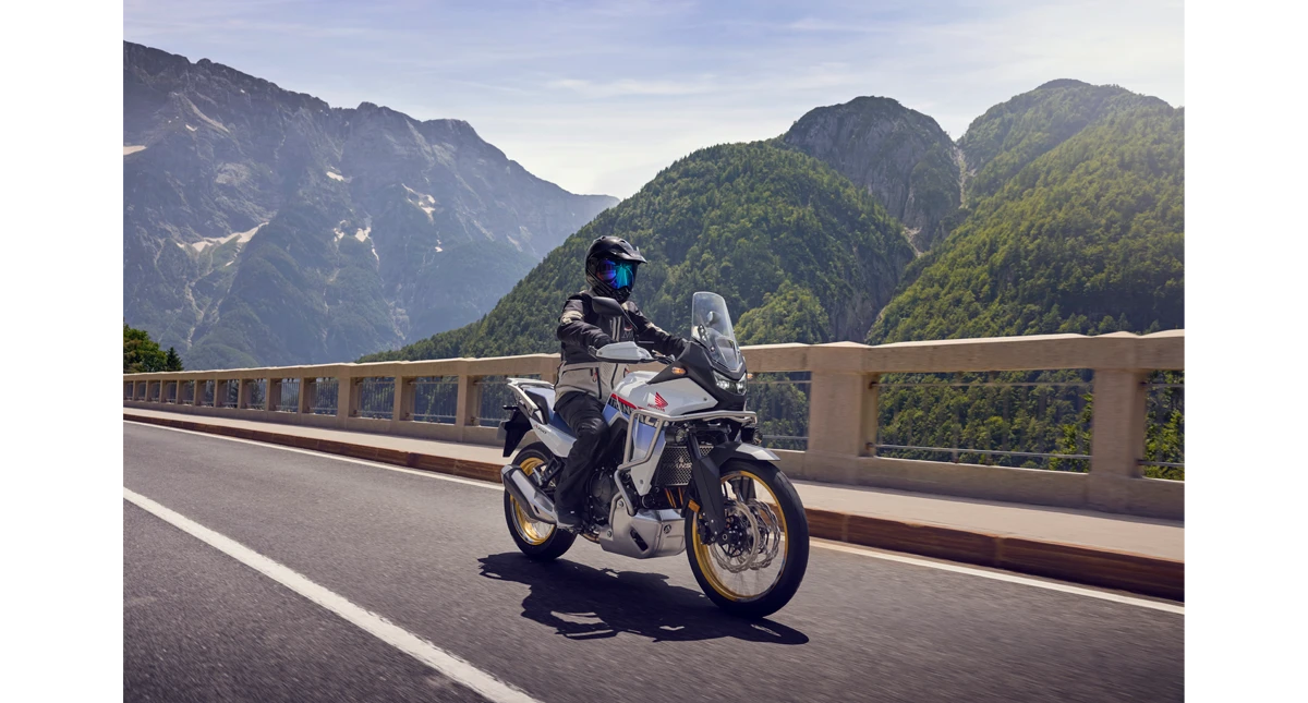Piloto em uma Honda Transalp passando por uma ponte