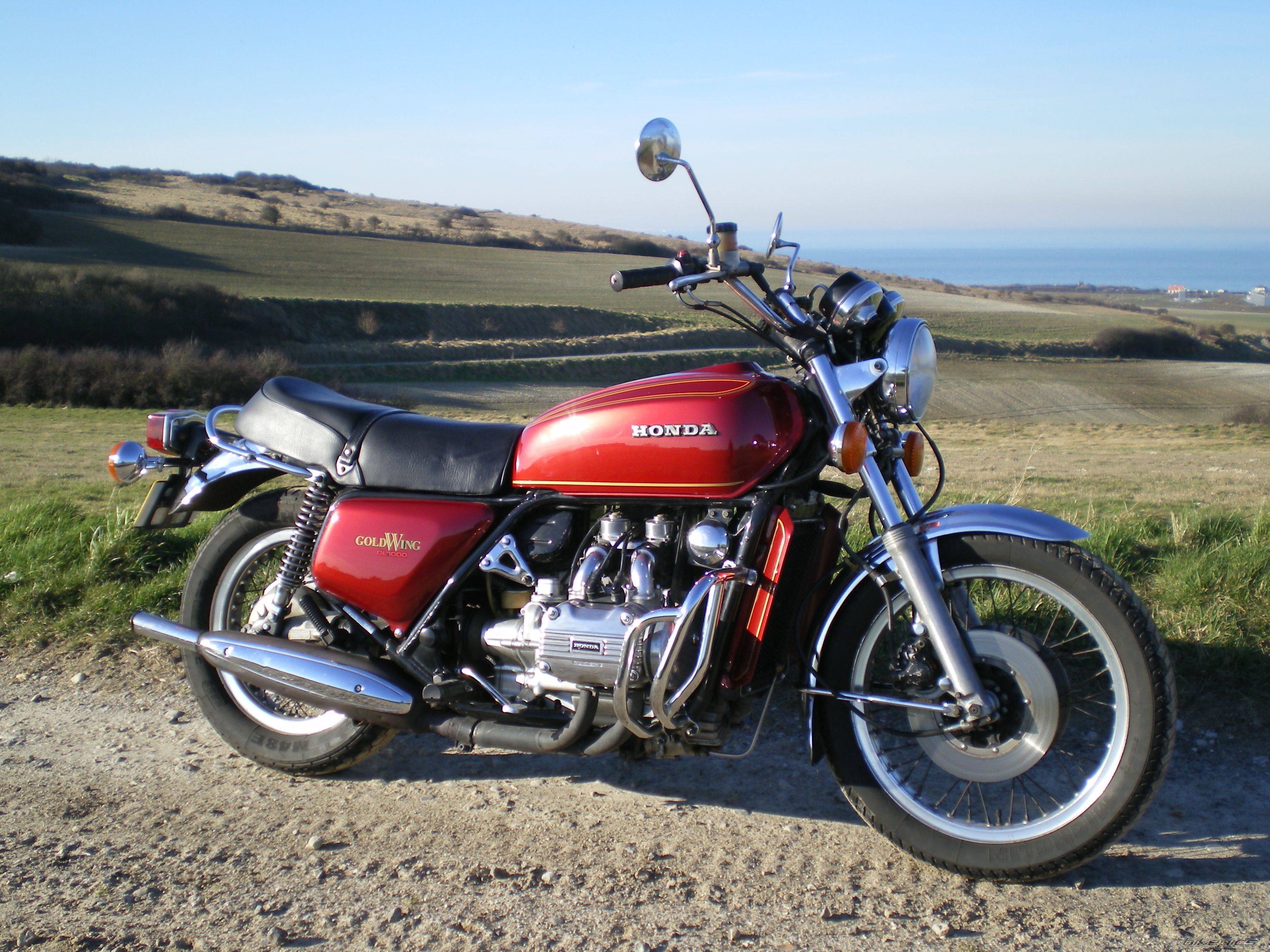 Moto Honda Gold Wing de 1974 vinho com paisagem ao fundo