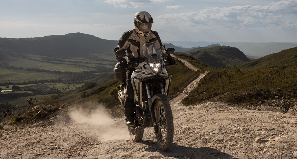 Piloto na moto Honda Sahara 300 em trilha usando o alerta de frenagem 