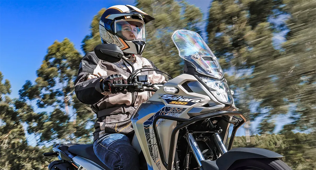 Piloto em sua Sahara 300 com luvas de proteção