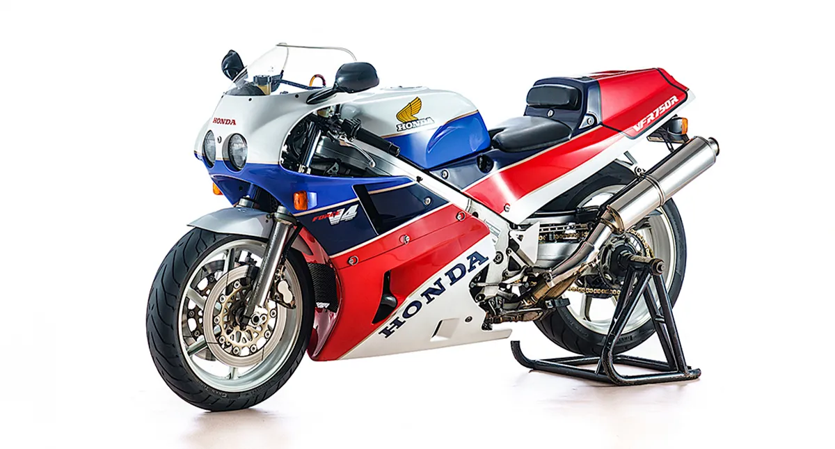 Moto honda colorida vista de lado com suporte 