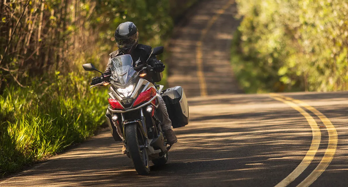 Piloto com sua Moto Honda NC 750X na estrada curva