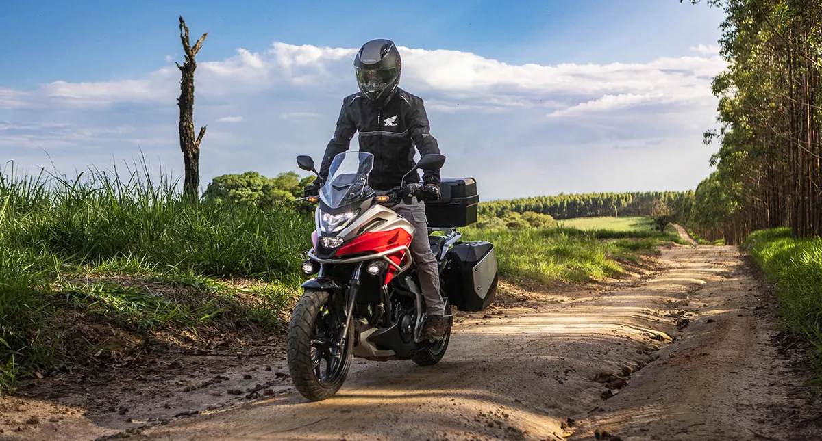 Piloto com sua Moto Honda NC 750X na estrada de terra