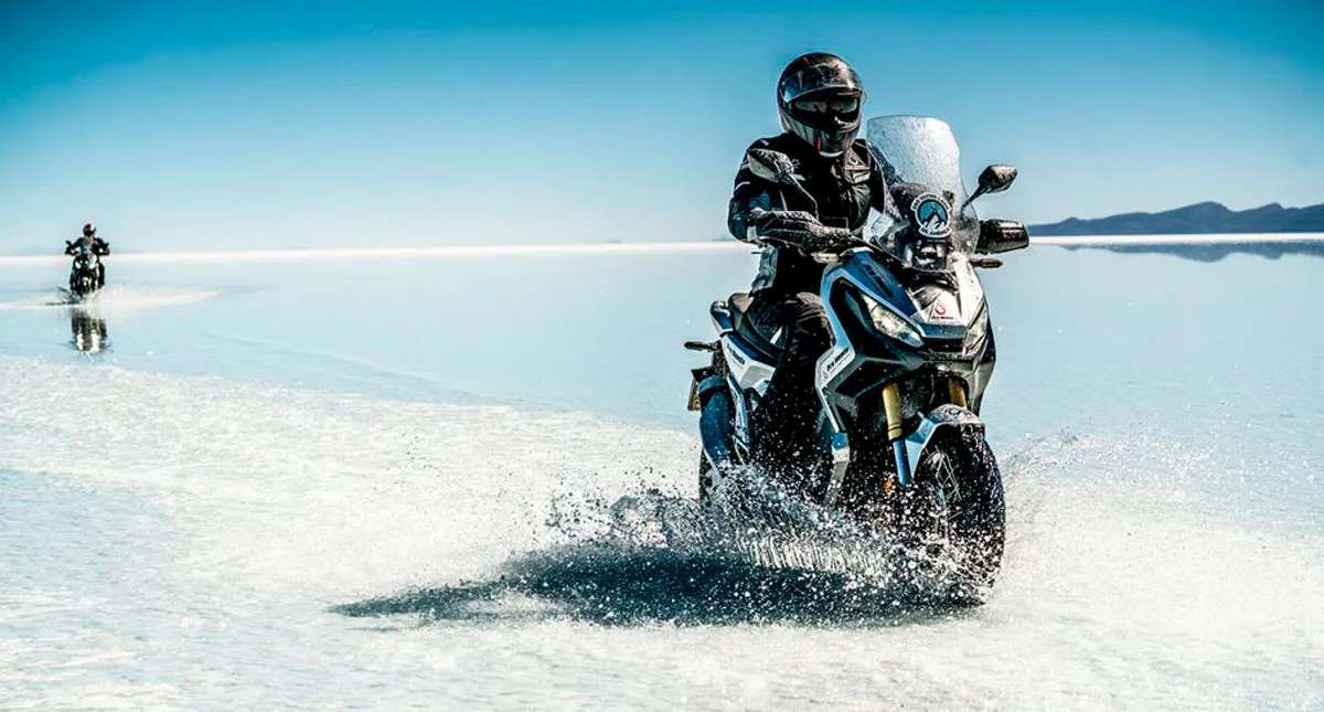 Dois pilotos em suas Scooters X-ADV na beira do mar