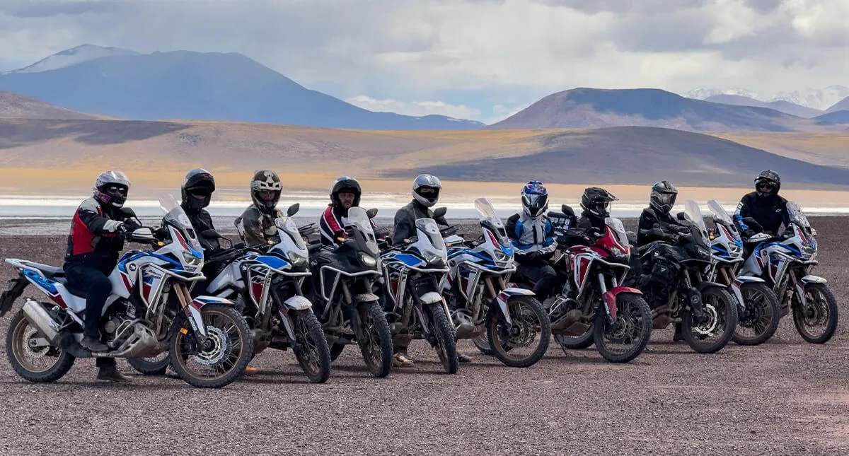 Pilotos em suas Honda CRF 1100L Africa Twin lado-a-lado com montanhas dos andes atrás