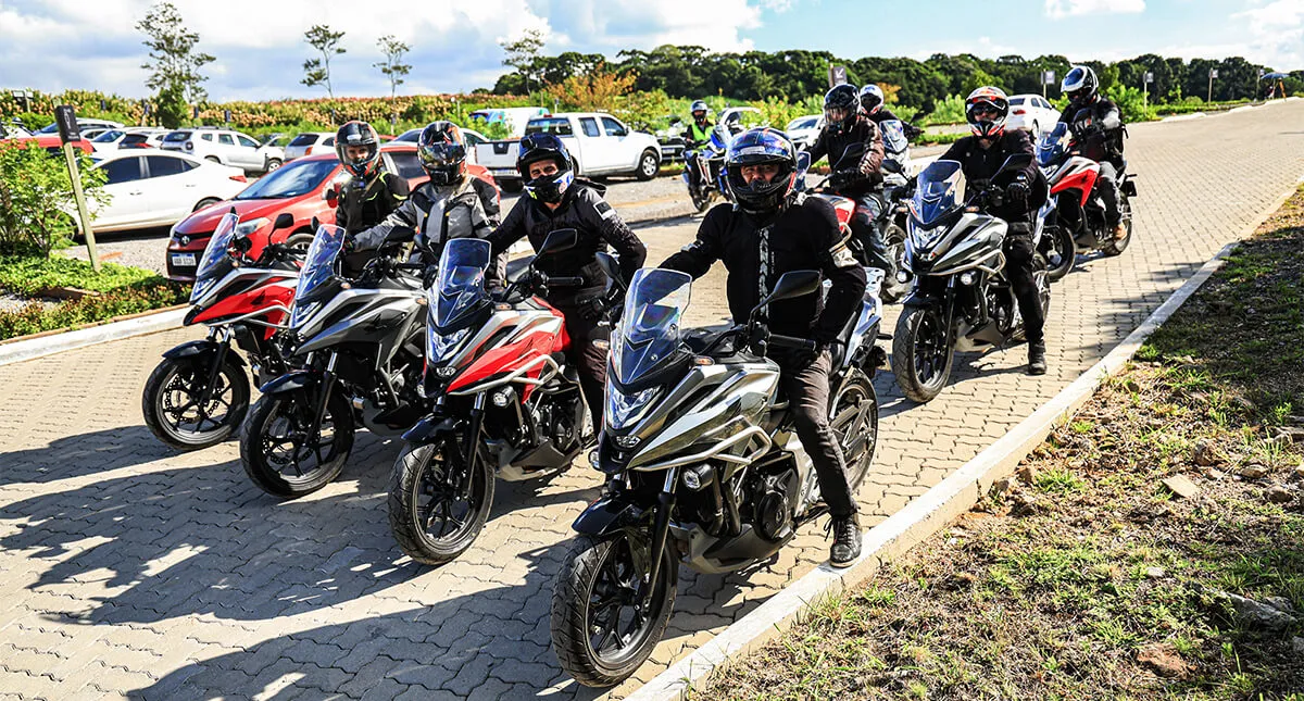 Oito pilotos em suas motocicletas prontos para iniciar viagem