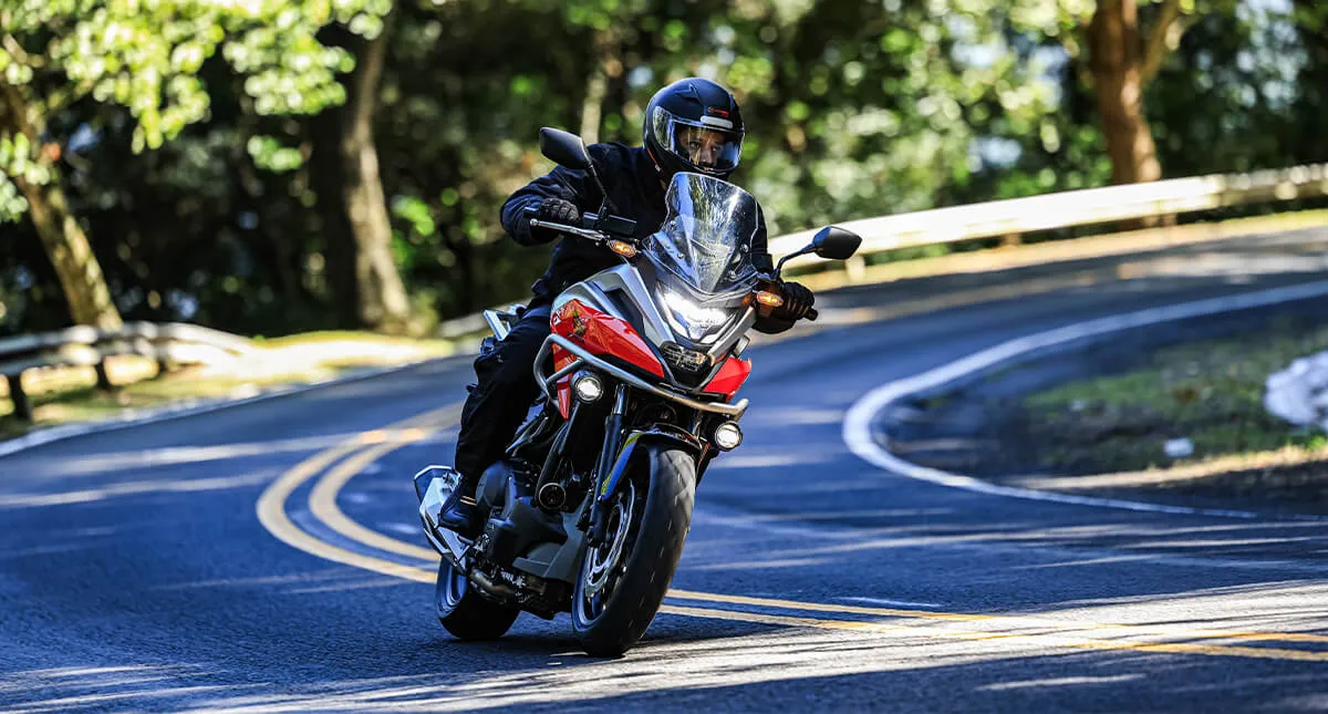 Piloto em sua Honda fazendo curva em estrada na serra gaúcha